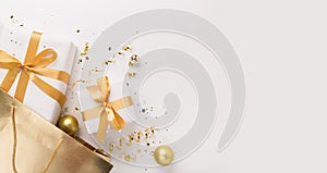Present boxes with gold ribbon inside shopping bag on white