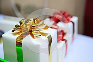 Present boxes package with gold and red ribbons as holiday gift boxes for festive giving seasons. Thanks, Happiness, Sharing,