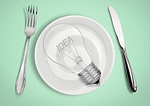 Present new idea concept. Light bulb on plate with fork and spoon.