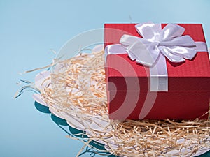 Present red box on blue background greeting card holidays concept.