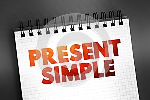 Present Simple - one of the verb forms associated with the present tense in modern english, text concept on notepad