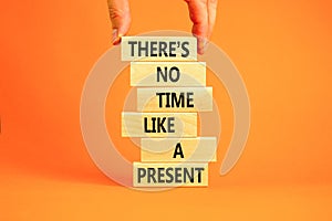 Present time symbol. Concept words There is no time like the present on wooden block. Beautiful orange table orange background.