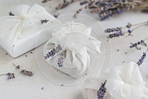 Present wrapped with white furoshiki fabric and decorated with lavender flowers. Eco friendly gift