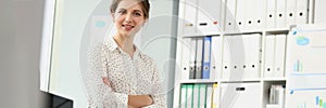 Presentable employee girl posing sitting on desk in office, stylish look for work