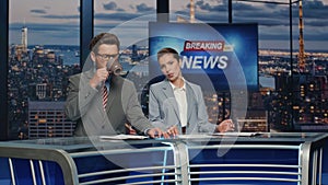 Presenters lighting breaking news in late tv studio closeup. Anchors discussing