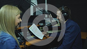 Presenters or moderators - man and woman - in radio station hosting show for radio live in Studio
