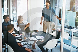 Presenting his ideas. High angle shot of a young businessman giving a presentation in the boardroom.