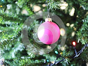 Presents for christmas, pink balls on the background of a green Christmas tree