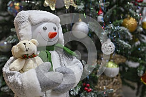 Presents and gifts with stuffed snowman under Christmas tree in living room. snowman under the tree Happy New Year