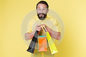 Presents make life more interesting. Man mature bearded cheerful face holds shopping bags. Man got unexpectable gifts