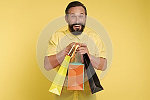 Presents make life more interesting. Man mature bearded cheerful face holds shopping bags. Man got unexpectable gifts