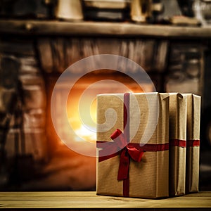 Presents in retro style on wooden board with fireplace background in a cozy home. Christmas winter time.