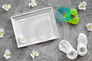 Presents set for baby shower with orchid and frame gray stone background top view mockup