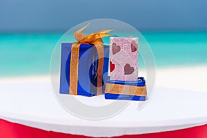 Presents on the table packed with ribbons for Saint Valentine\'s day holiday at the tropical beach