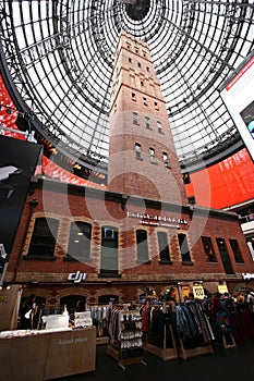 Preserving old historic brick Coop`s Shot Tower indoor under modern black steel truss glass dome inside Melbourne Central Mall