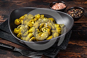 Preserved Jalapenos, pickled and sliced in plate . Dark Wooden background. Top view