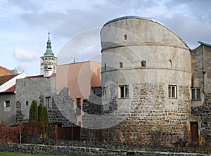 Preserved mediaeval walls and bastion with a church tower in the background