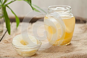 Preserved pineapple circles with juice in glass on vintage cloth