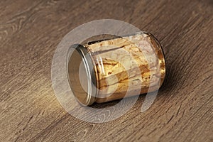 Preserved tuna fish fillets in a glass jar. Isolated on a wooden