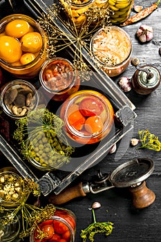 Preserved vegetables and mushrooms in a box with seamer.