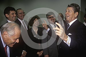 President Ronald Reagan jokes with politicians and reporters