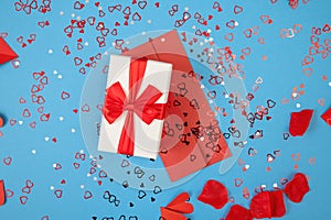 Presnet with envelope lying on blue background with glitters around