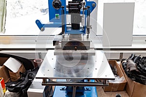 Press machine in the workshop for doing the embossed logo and letters on the leather product that heats the cliche and squeezes