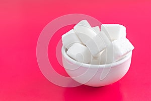 Pressed sugar cubes in a ceramic Cup