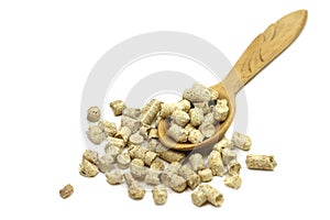 Pressed wooden pellets in a spoon