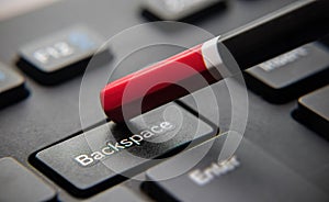 Pressing `backspace` button on black keyboard with pencil