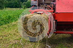 Pressing hay into bales, old working press, harvesting and harvesting dry fodder