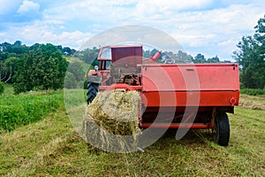 Pressing hay into bales, old working press, harvesting and harvesting dry fodder