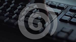 Pressing key with your finger. Closeup of male finger presses button on black computer keyboard. Man nervously presses