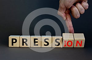 Pression to free press symbol. Businessman turns wooden cubes and changes the word pression to press. Beautiful grey table, grey