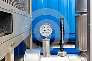 The pressure Gage and thermometer in water cold pipe on air condition system.