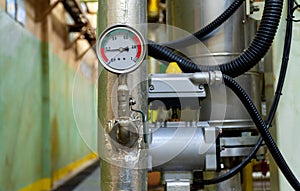 The pressure gauge dial installed to the pipe wrapped with insulation.