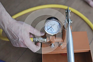 Pressure tester pump is in the hands of a worker