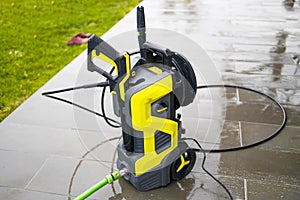 Pressure washer cleaning machine on wet concrete floor near the house build, cleaning terrace with a power washer