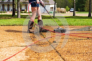 Pressure washing to clean driveway of a home