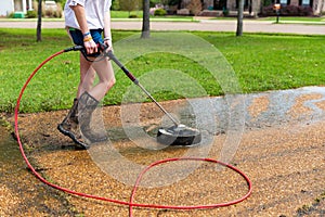 Pressure washing to clean driveway of a home