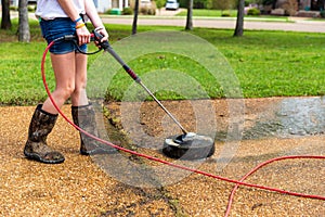 Pressure washing to clean driveway of a home