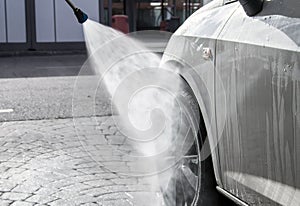 Pressure water jet over car tire at car wash