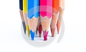 Pressuring bunch of different colored wood pencil on a white paper background