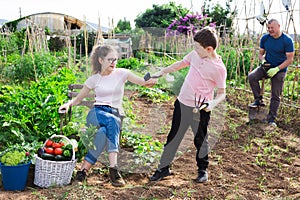 Preteen boy calling sister to work in vegetable garden