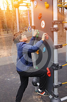 Preteen boy climbing a rock wall outdoors