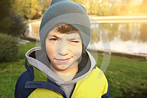 Preteen boy in knitted hat and down jacket