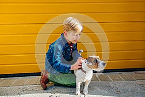 Preteen boy playing with hid dog Jack Russell Terrier