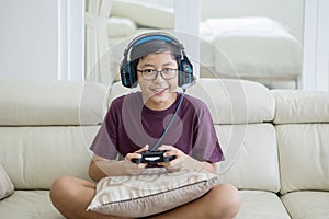 Preteen boy playing video games with a joystick