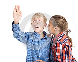 Preteen boy with rised hand and young girl wispering, children in checkered shirts isolated on white background photo