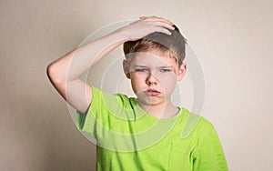 Preteen boy sad offended with bruise and scratch on his face portrait on white wall background